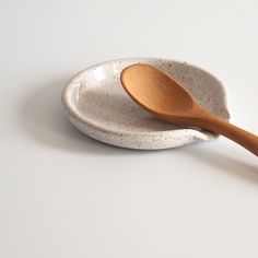 a wooden spoon sitting on top of a white ceramic bowl next to a wooden spoon