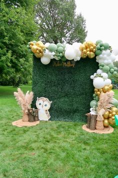 an owl themed birthday party with gold and white balloons, greenery, and decorations