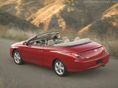 a red convertible car driving down the road