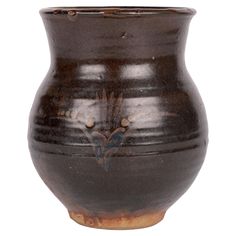 a brown vase sitting on top of a white table