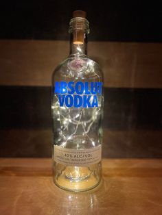 a bottle of absolut vodka sitting on top of a wooden table