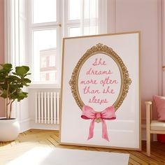 a pink room with a framed poster and potted plant on the floor next to it