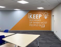 an office with desks, chairs and a sign on the wall that says keep showing up when most people quit