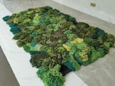 a rug made out of moss on the floor in a room with marble floors and walls