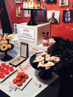 a table topped with lots of desserts and pastries next to pictures on the wall