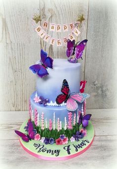 a birthday cake decorated with butterflies and flowers