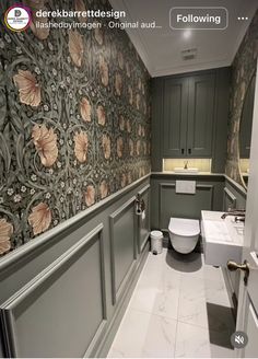 a bathroom with floral wallpaper and white toilet next to sink in the middle of the room