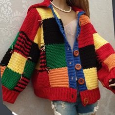 a doll is wearing a colorful jacket and jeans