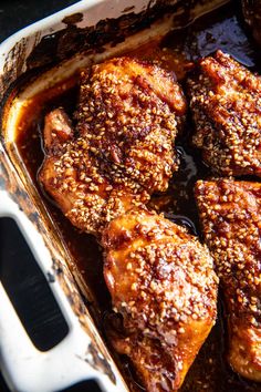 some meat is cooking in a pan on the stove top with sauce and seasoning