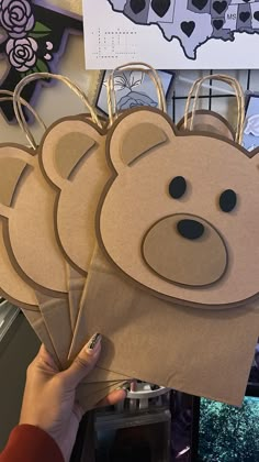 a person holding up some brown paper bags with bear faces on them and the map of the united states in the background