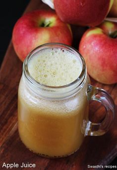 an apple juice in a mason jar next to some apples