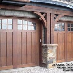 two wooden garage doors with arched windows