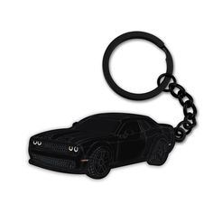 a black car shaped keychain on a white background with the image of a sports car