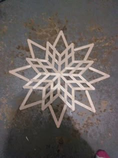 a paper snowflake sitting on top of a metal table next to a pair of shoes