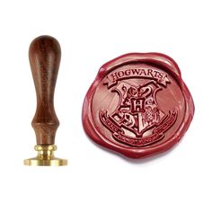 a waxed stamp with the hogwarts crest on it and a wooden handle