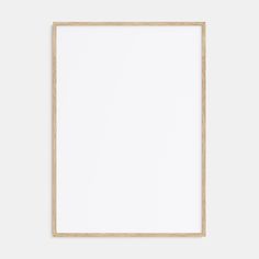 an empty wooden frame hanging on the wall with a white paper in front of it