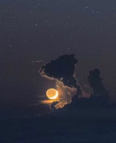 the moon is shining brightly in the night sky above clouds and stars as seen from an airplane