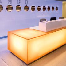 an airport lounge area with white walls and round lights on the counter, along with large circular windows