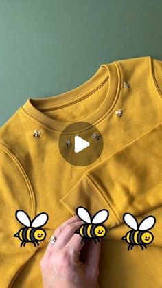 someone is cutting out some bees on a t - shirt to make it look like they are