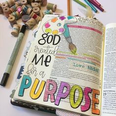 an open bible next to some crayons and pencils