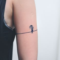 a woman with an umbrella tattoo on her arm is holding the string that she has attached to