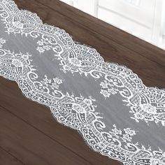 a white lace is laying on top of a wooden table