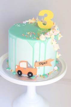 a birthday cake decorated with a truck and number three