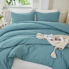 a bed with blue comforters and white pillows