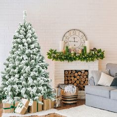 a living room with a christmas tree and presents on the floor next to a fireplace