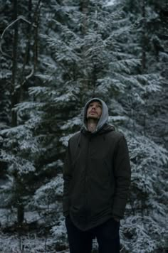 a man standing in the snow with his eyes closed