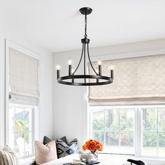 a dining room table with four chairs and a chandelier hanging from the ceiling