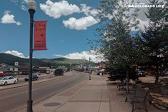 an empty street with cars parked on the side and a red sign that says stay local