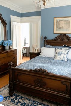 a bedroom with blue walls and wooden furniture