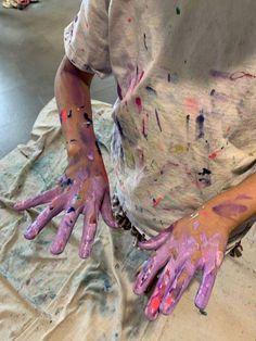 a person with their hands covered in paint