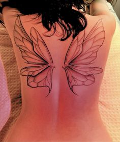 a woman's back with a butterfly tattoo on her lower back and the upper part of her body