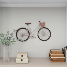 a bicycle mounted to the wall next to some boxes and a vase with a plant in it