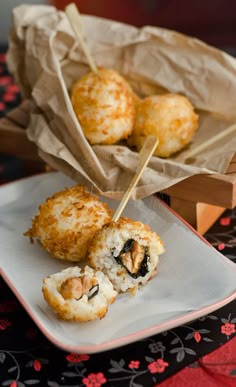 some food is sitting on a white plate and next to a brown paper bag with red flowers