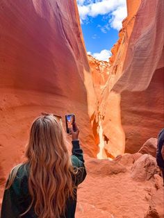 a woman is taking a photo in the canyon