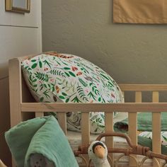 a stuffed animal sitting in a crib next to a pillow