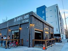 the outside of a restaurant with people sitting at tables