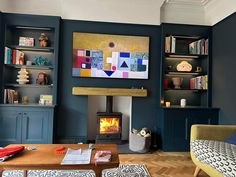 a living room filled with furniture and a fire place in front of a book shelf