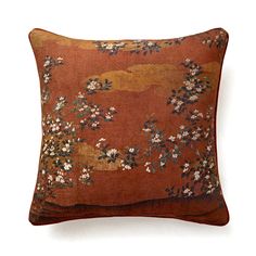 an orange and brown pillow with flowers on it