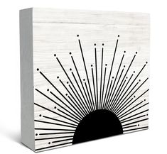 a wooden block with black and white lines on it, in the shape of a sunburst