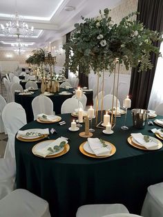 the tables are set with white and green linens, gold place settings and candles