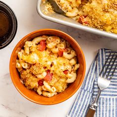 a bowl filled with macaroni and cheese next to a casserole dish