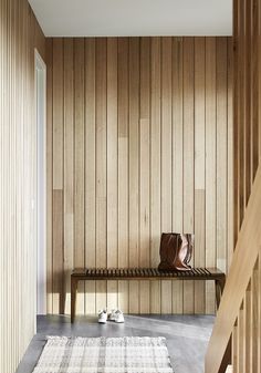 a wooden bench sitting next to a white rug