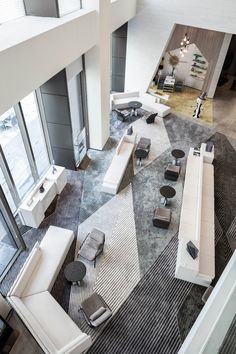 an aerial view of a living room with white couches and black chairs in it