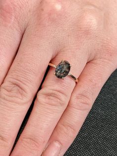 a woman's hand with a ring on it and a stone in the middle