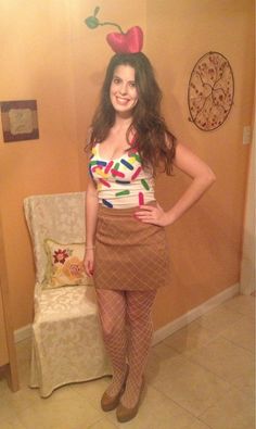 a woman standing in front of a chair wearing tights and an apple t - shirt