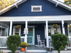 a blue house with white trim and front porch